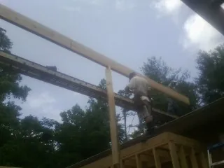 Carpenter setting a ridge beam over a new addition frame — Ice Dam Removal by Roofing Brothers in Buckholts