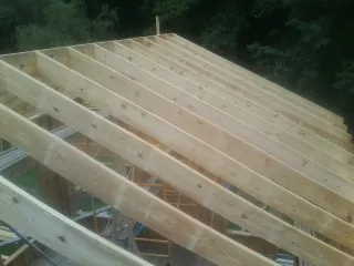 New roof rafters set over an addition before sheathing in Buckholts