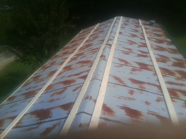 Rusted metal roof panels with new wood purlins before replacement — Storm Damage Roof Repair in Buckholts by Roofing Brothers