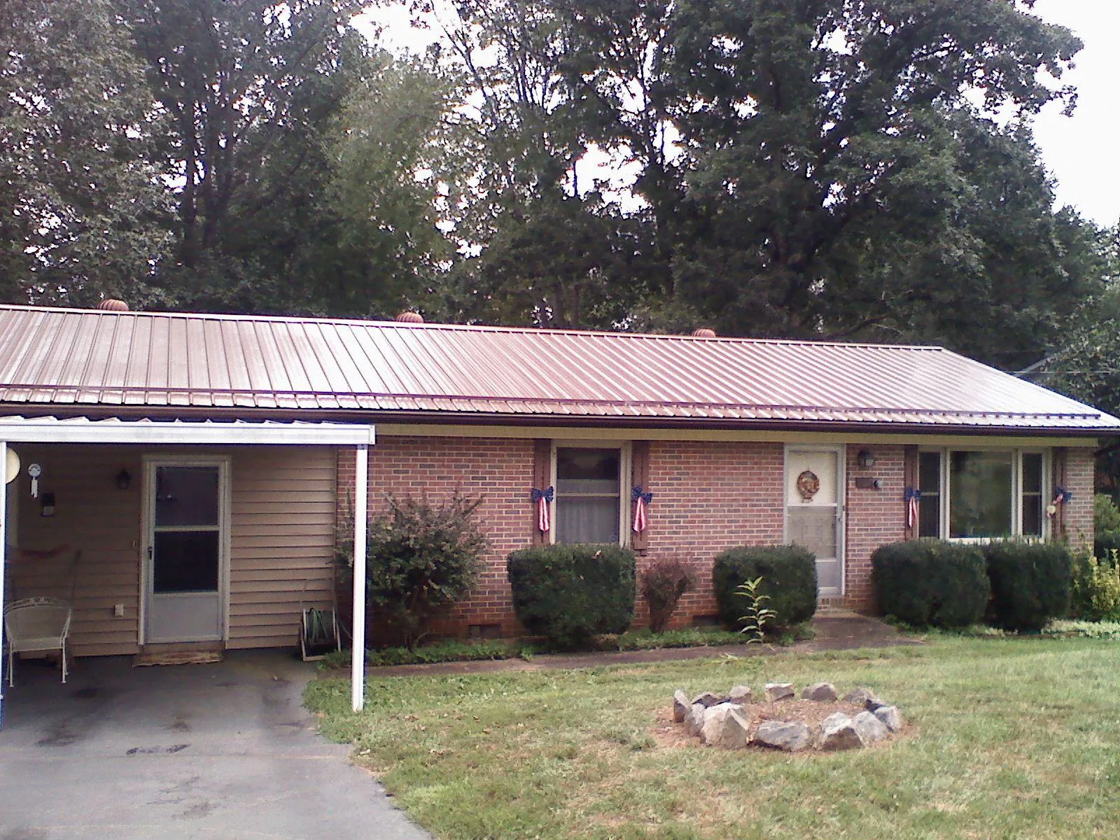 Bronze metal roof and carport on a brick ranch home — Roof Repair work by our crew in Buckholts